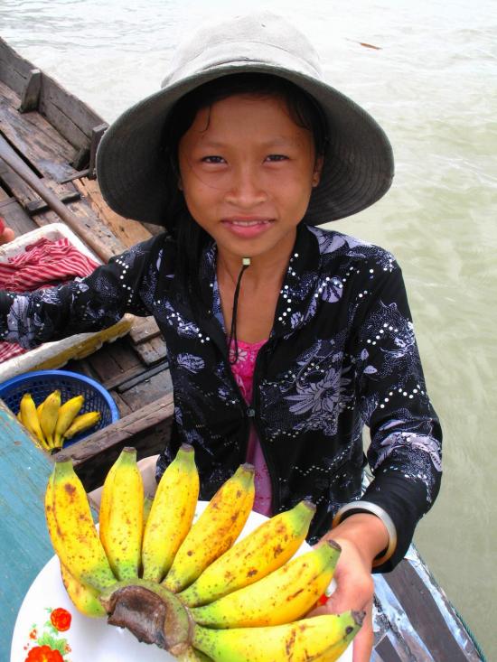 Tie your boat up carefully alongside a big boat and sell bananas you picked in Cambodia.